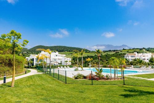 een hek voor een zwembad met huizen bij Alcazaba Lagoon Apartment with Private Beach, Pools, Gym, Sauna, Hot Tub & Fully Equipped Kitchen in Casares