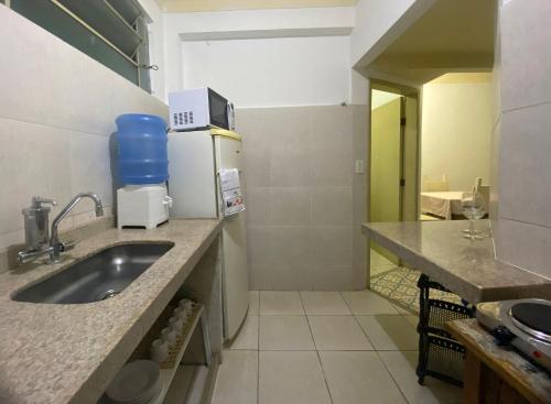 a kitchen with a sink and a refrigerator at Casa no centro histórico de São João del- Rei in São João del Rei