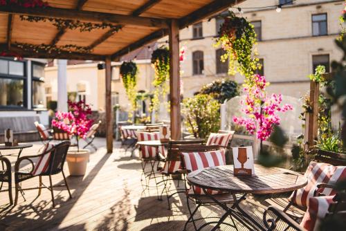 an outdoor patio with tables and chairs and flowers at LouLou in Berg en Terblijt