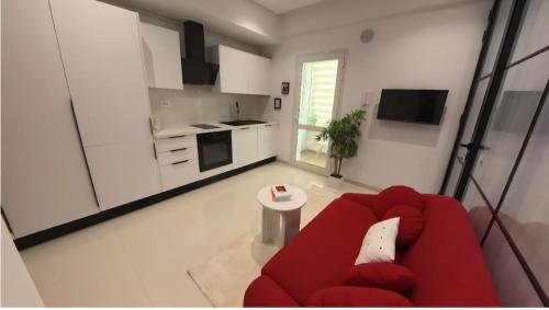 a living room with a red couch and a kitchen at Farah in Sousse