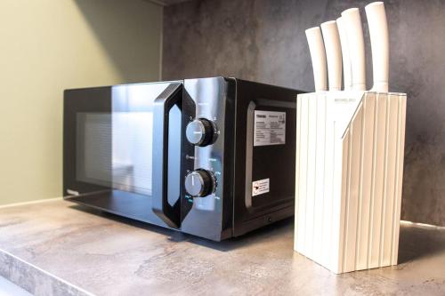 un micro-ondes sur un comptoir à côté d'un bloc de couteaux dans l'établissement Romantische Wohnung in der Moselregion, à Treis-Karden