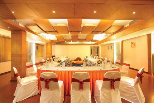 a conference room with a large table with white chairs at Hotel Park Residency, Kakkanad in Kakkanad