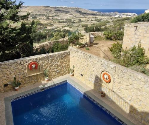a villa with a swimming pool with a view at Sunset Castle House with Pool in Xagħra