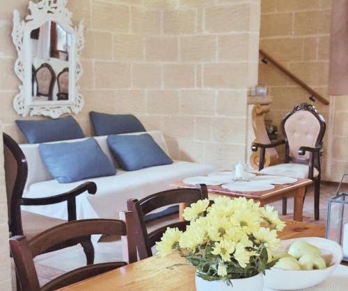 a living room with a couch and a table at Sunset Castle House with Pool in Xagħra