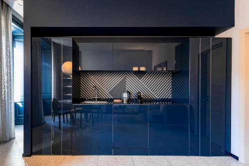 une cuisine avec des armoires bleues et une table dans l'établissement Palazzo Visconti - by MyHomeInComo, à Côme