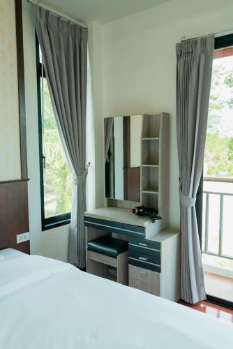 a bedroom with a bed and a desk with a mirror at Baan Viset Pool Villa Krabi in Ao Nang Beach