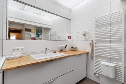 Un baño blanco con lavabo y espejo. en Casa Rose Pere, en Hoffenheim