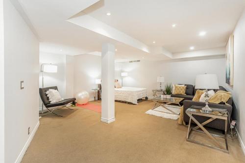 ein Wohnzimmer mit einer Couch und einem Bett in der Unterkunft House of 3 Bed 3 Wash-Crib-King Bed-85' TV-Wrkspce in Oakville