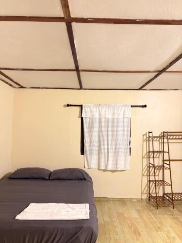 a bedroom with a bed and a towel hanging on a wall at Silver Cliff Bungalow in Than Sadet Beach