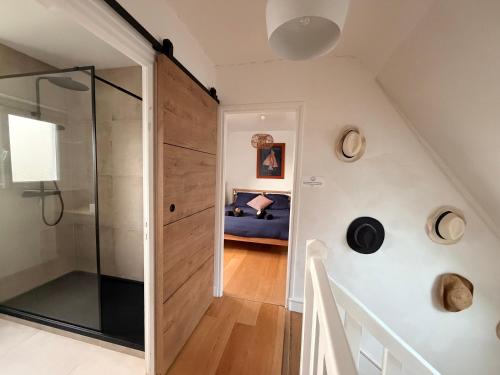 ein Badezimmer mit einer Glastür, die zu einem Schlafzimmer führt. in der Unterkunft Ty Glou Maison Charmante - 5m plage in Ploemeur