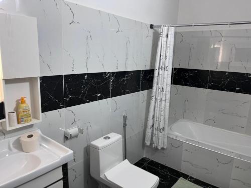 Un baño con un inodoro blanco y un lavabo. en Keur joie, en Mbour