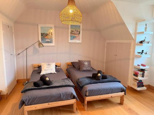 ein Schlafzimmer mit zwei Einzelbetten und einem Kronleuchter in der Unterkunft Ty Glou Maison Charmante - 5m plage in Ploemeur