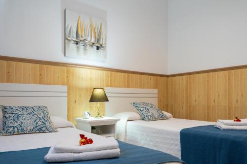 a hotel room with two beds and a table at Ocean views "Las Garzas" in Sardina