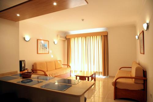 a living room with a couch and a table at Aparthotel Calema Avenida Jardim in Monte Gordo