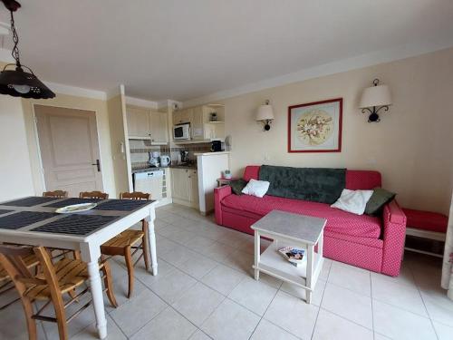 ein Wohnzimmer mit einem roten Sofa und einem Tisch in der Unterkunft Maison 3 pièces domaine golf Pont Royal in Mallemort