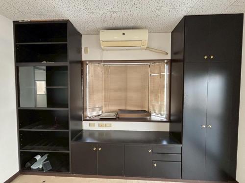 a kitchen with black cabinets and a window at K5 Building - Vacation STAY 20273 in Nabegayato