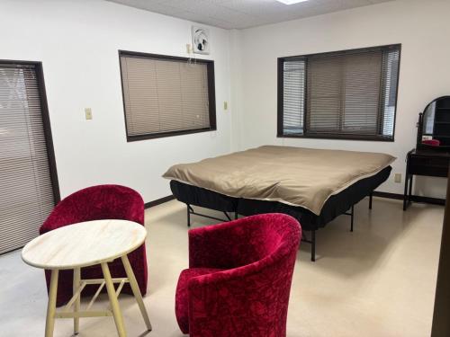 a room with a bed and two chairs and a table at K5 Building - Vacation STAY 20273 in Nabegayato