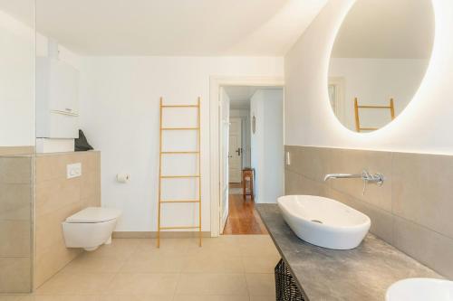 a bathroom with a sink and a toilet and a mirror at Historic Villa In North Frisia in Ostenfeld