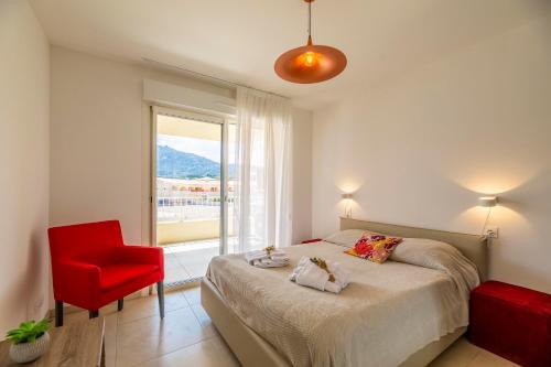 a bedroom with a bed and a red chair at Residence A Marina in Lumio