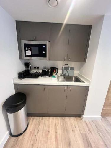 a small kitchen with a sink and a microwave at Studio Flat Close to Queen Square - Flat 4B in Bristol