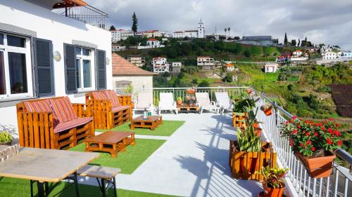 a patio with chairs and tables on a balcony at Apartamento Barros in Estreito de Câmara de Lobos