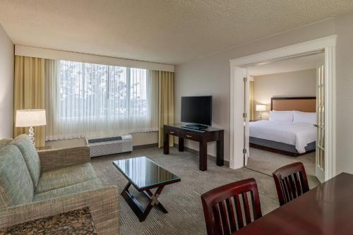 Una habitación de hotel con una cama y una sala de estar. en Holiday Inn & Suites Boston Peabody by IHG, en Peabody