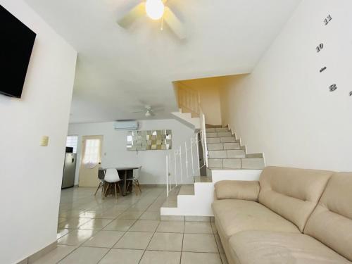 ein Wohnzimmer mit einer Couch und einer Treppe in der Unterkunft Casa al Norte, cerca Zona Industrial, Bien ubicado in Ramos Arizpe
