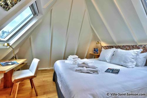 a bedroom with a bed and a desk and a window at Villa Saint Samson in Trégastel