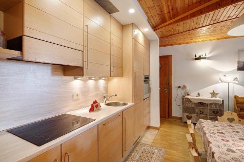 a kitchen with wooden cabinets and a sink at Matteo's apartment by Alpenwhite in Livigno