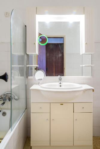 a white bathroom with a sink and a shower at Casa Sol e Praia in Luz