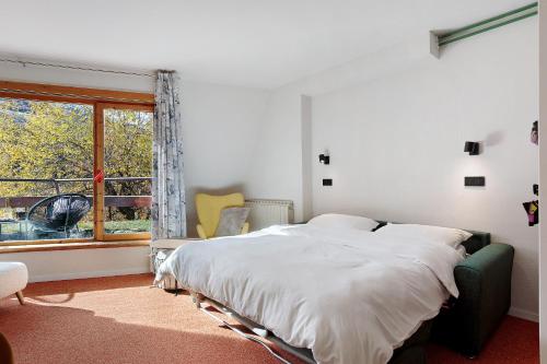 a white bedroom with a bed and a window at Ma Chérie-Lumière in Pila