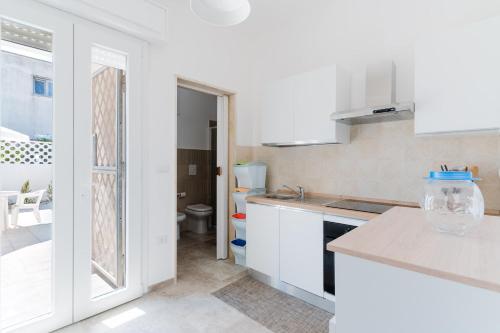 une cuisine blanche avec un évier et des toilettes dans l'établissement Villa Greta, à Isola della Malva