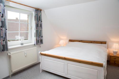 Ferienhaus Irle في Neukirchen: غرفة نوم بسرير أبيض ونافذة