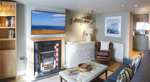a living room with a fireplace and a tv at Five Star Stays in Scarborough