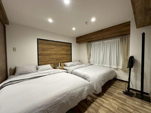 zwei nebeneinander stehende Betten in einem Schlafzimmer in der Unterkunft NEW PS508 Susukino Family Room in Wada