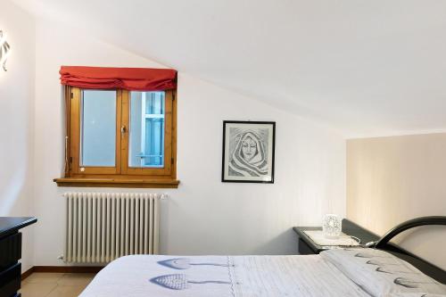 un dormitorio con una cama y una ventana en Casa Vacanze Dal Castelin, en Valtellina