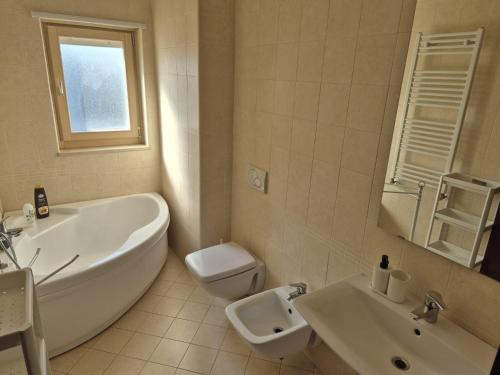 a bathroom with a tub and a toilet and a sink at mirosa airport home in Macchie