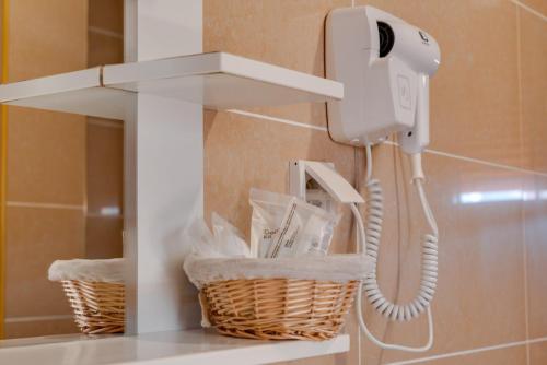 a phone hanging on a wall in a bathroom at DolceVita Lux & SPA in Vrnjačka Banja