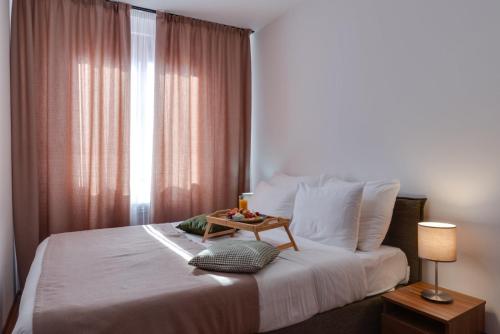 a bedroom with a bed with a table on it at DolceVita Lux & SPA in Vrnjačka Banja