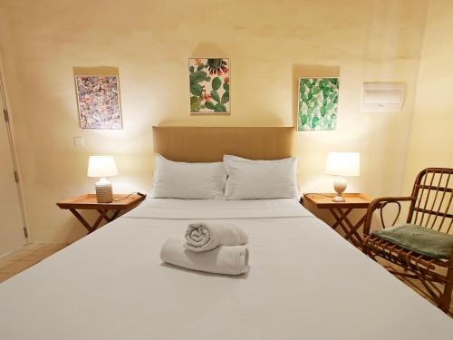 a bedroom with a large white bed and two chairs at Birgu 3 in Cospicua