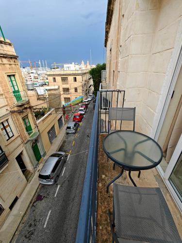 un tavolo sul balcone di un palazzo con vista sulla strada di Birgu 3 a Cospicua