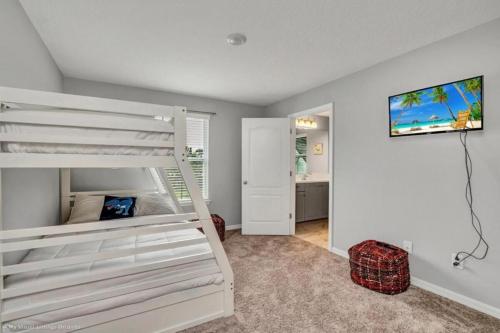 a bedroom with a white bunk bed and a desk at Sunny Amp Bright Modern Retreat in Davenport