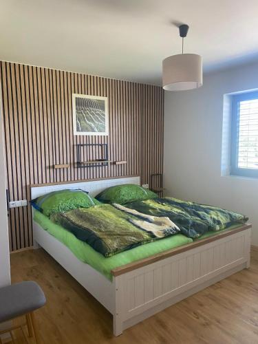 a bedroom with a bed with green sheets and a window at Apartmány MB JARO Mladá Boleslav in Bradlec