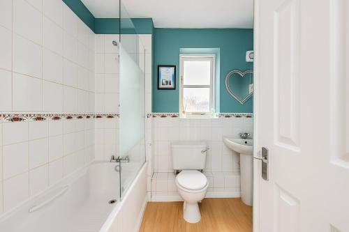 a bathroom with a toilet and a tub and a sink at Tattenhoe House with Free Parking, Fast Wifi, Garden and Smart TV by Yoko Property in Milton Keynes