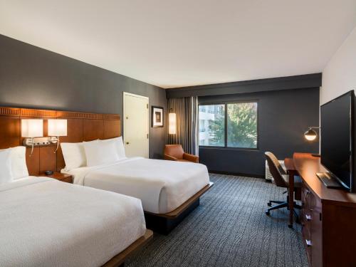 een hotelkamer met twee bedden en een bureau bij Courtyard Sacramento Airport Natomas in Sacramento