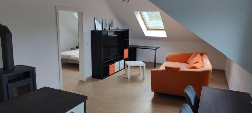 a living room with a chair and a television at Grüne Auszeit Dresden in Dresden