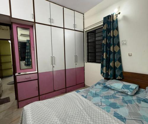 een slaapkamer met paarse en witte kasten en een bed bij 3BHK Flat Rudrashakti Enclave Nagpur in Nagpur