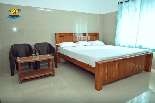 a bedroom with a bed and two chairs and a table at vks holiday homes in Malpe