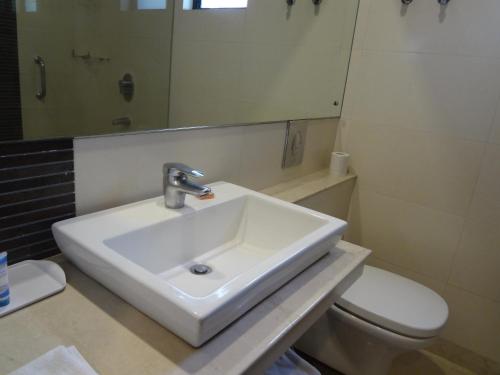 a bathroom with a sink and a toilet at The Legend Inn @Nagpur in Nagpur