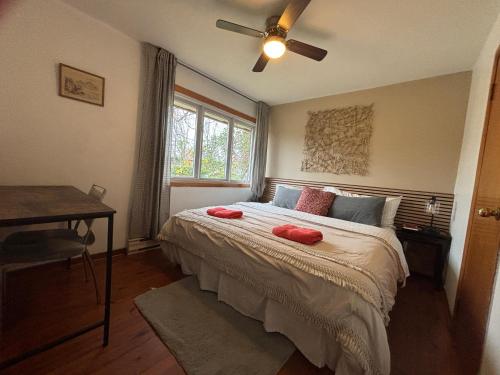 um quarto com uma cama com duas almofadas vermelhas em Entire floor in a Spacious bungalow ensuite close to beach and train em Pincourt